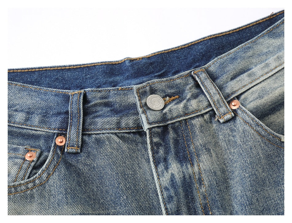 Close-up of the jeans’ waistband, button, belt loops, fly stitching and copper-colored rivets.