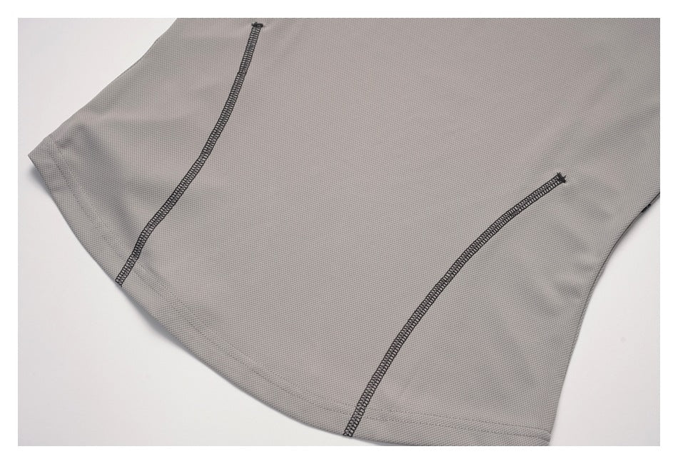 Close-up of a light gray garment panel with two curved dark overlock seams and a stitched edge.