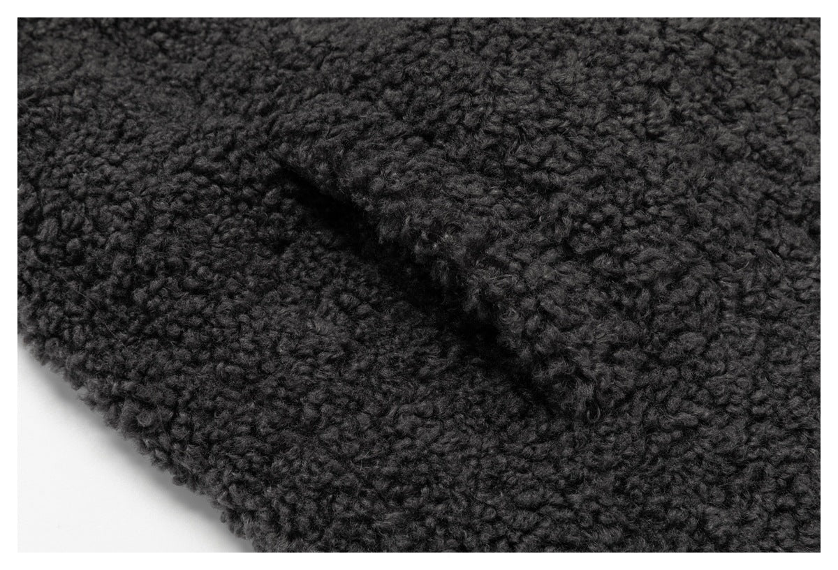 Close-up of charcoal nubby fabric showing a raised diagonal seam or folded edge.
