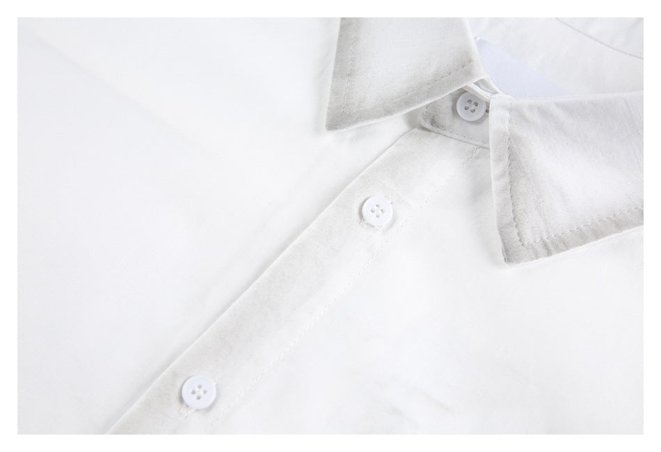 Close-up of a white shirt collar, button placket, and white buttons.