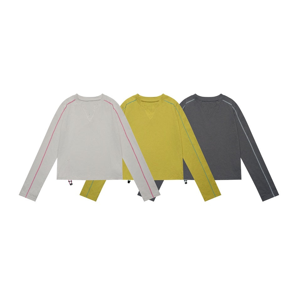 Three long-sleeve tops shown from the front in light gray, mustard, and charcoal, with contrast raglan seams.