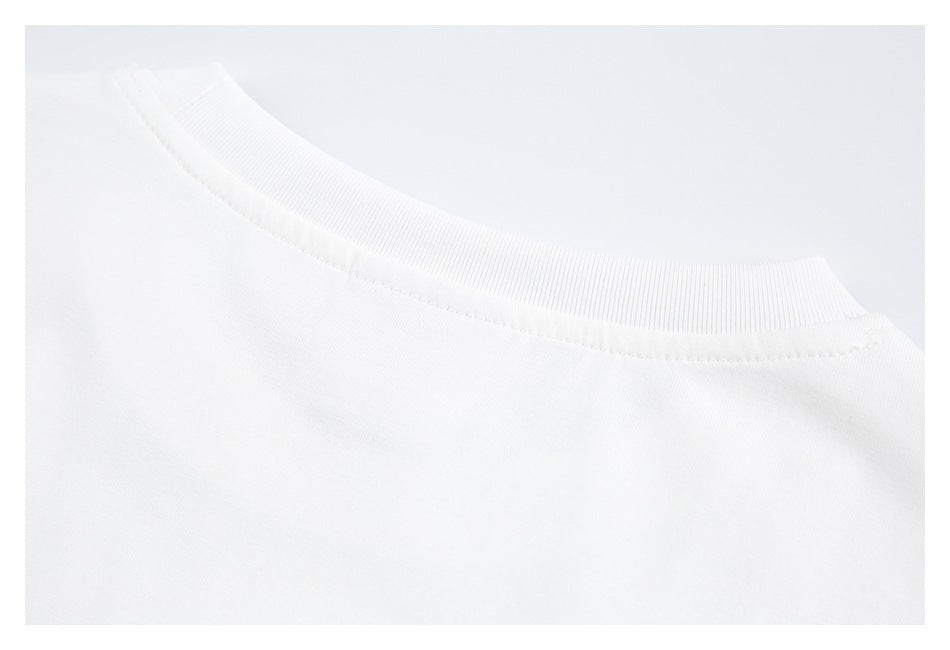 Close-up of the ribbed crew neckline and shoulder seam of a white garment.
