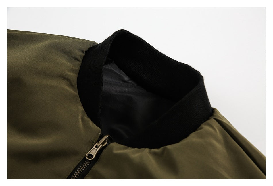 Close-up of an olive jacket with a black ribbed collar and front zipper.