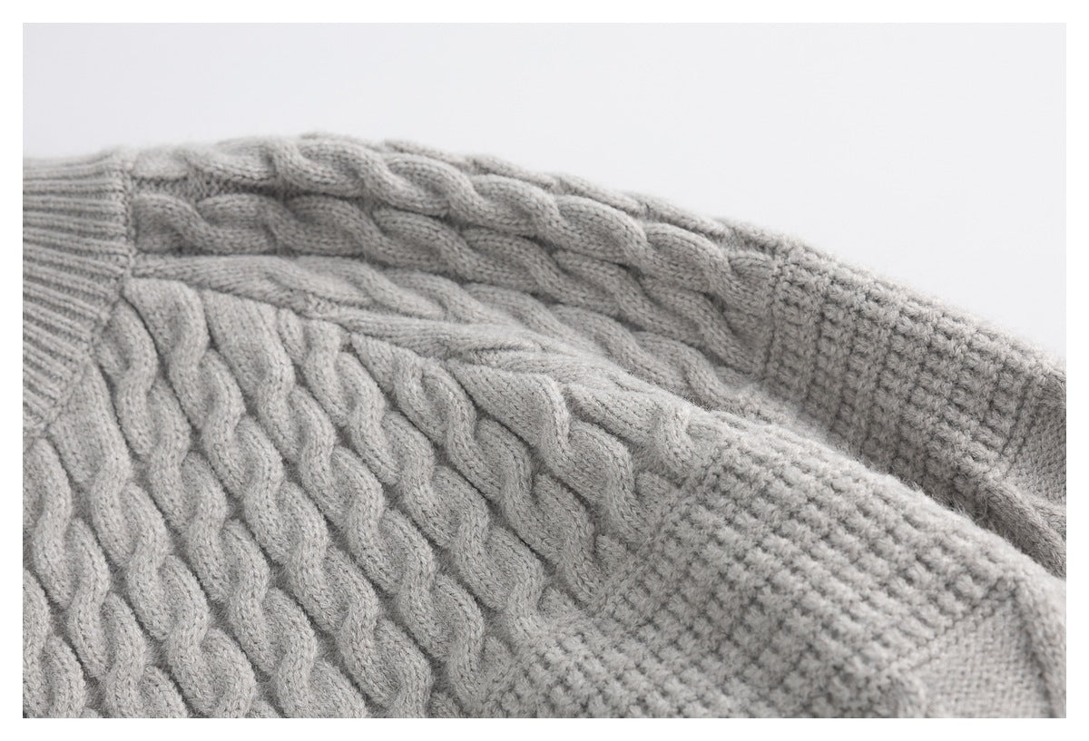 Close-up of the light gray cardigan's raised cable-knit pattern and textured sleeve section.
