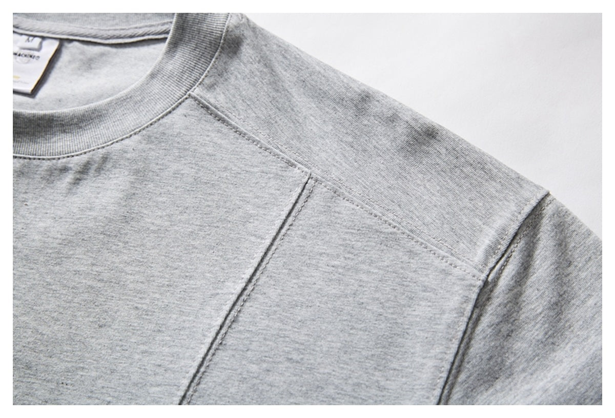 Close-up of a heather gray T-shirt showing the ribbed crew neckline and shoulder stitching.