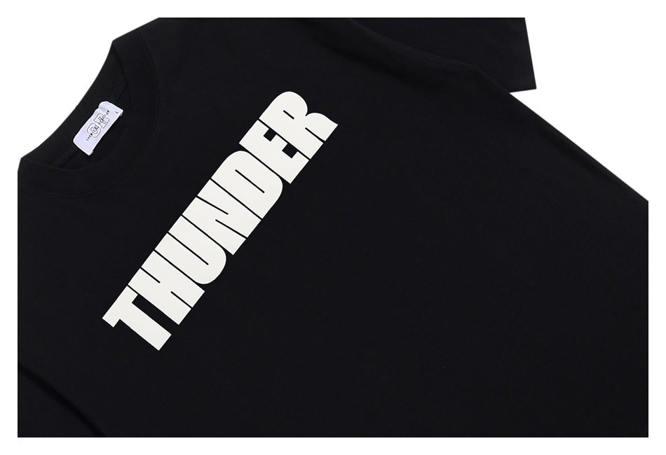 Close-up of black T-shirt collar, neck label and angled white THUNDER chest print