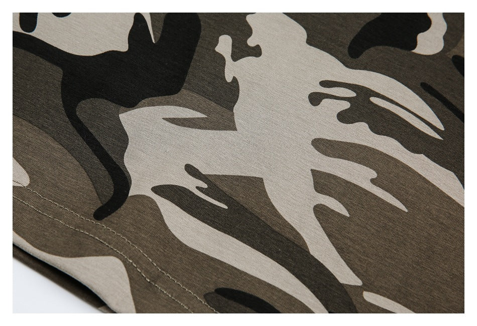 Close-up of camouflage fabric with a curved stitched hem along the edge.