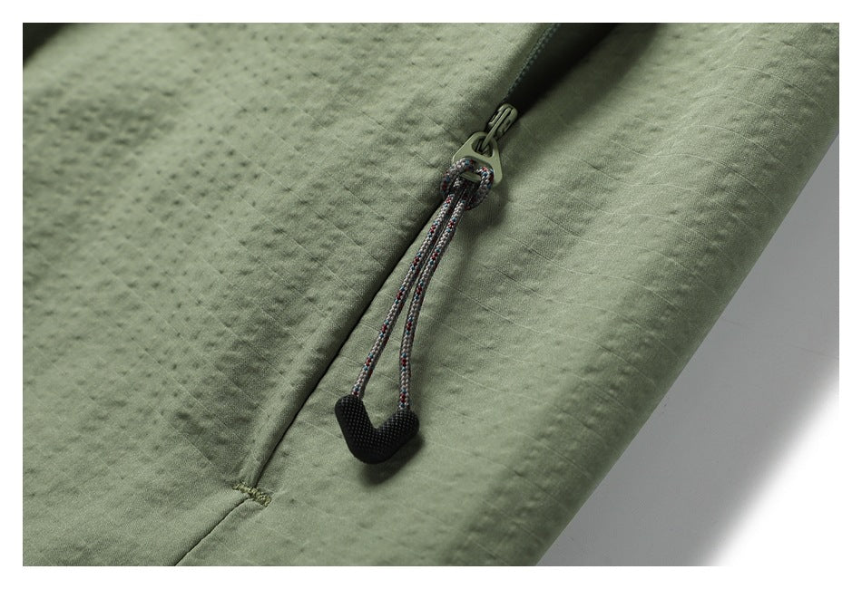 Close-up of a skirt pocket zipper with a braided cord pull and black grip.