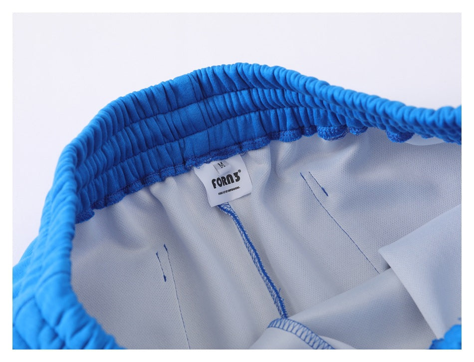 Inside view of bright blue pants showing the waistband stitching and a sewn-in size and brand label.