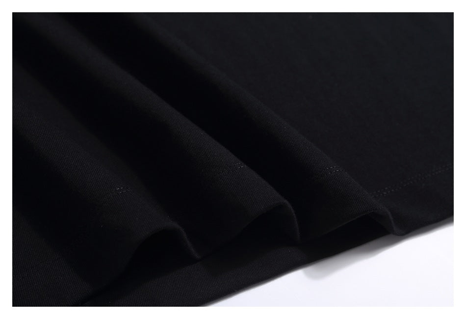 Close-up of softly draped black T-shirt fabric and a stitched edge.