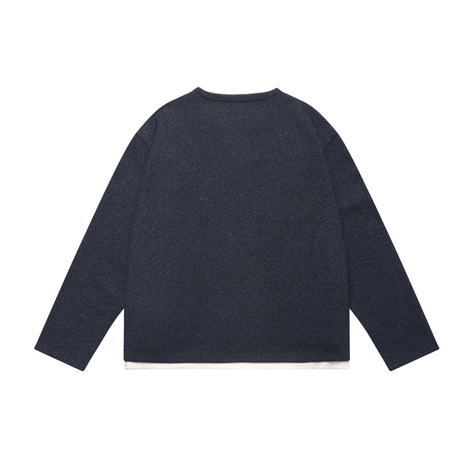 Back view of a navy long-sleeve top with a white layer peeking below the hem.