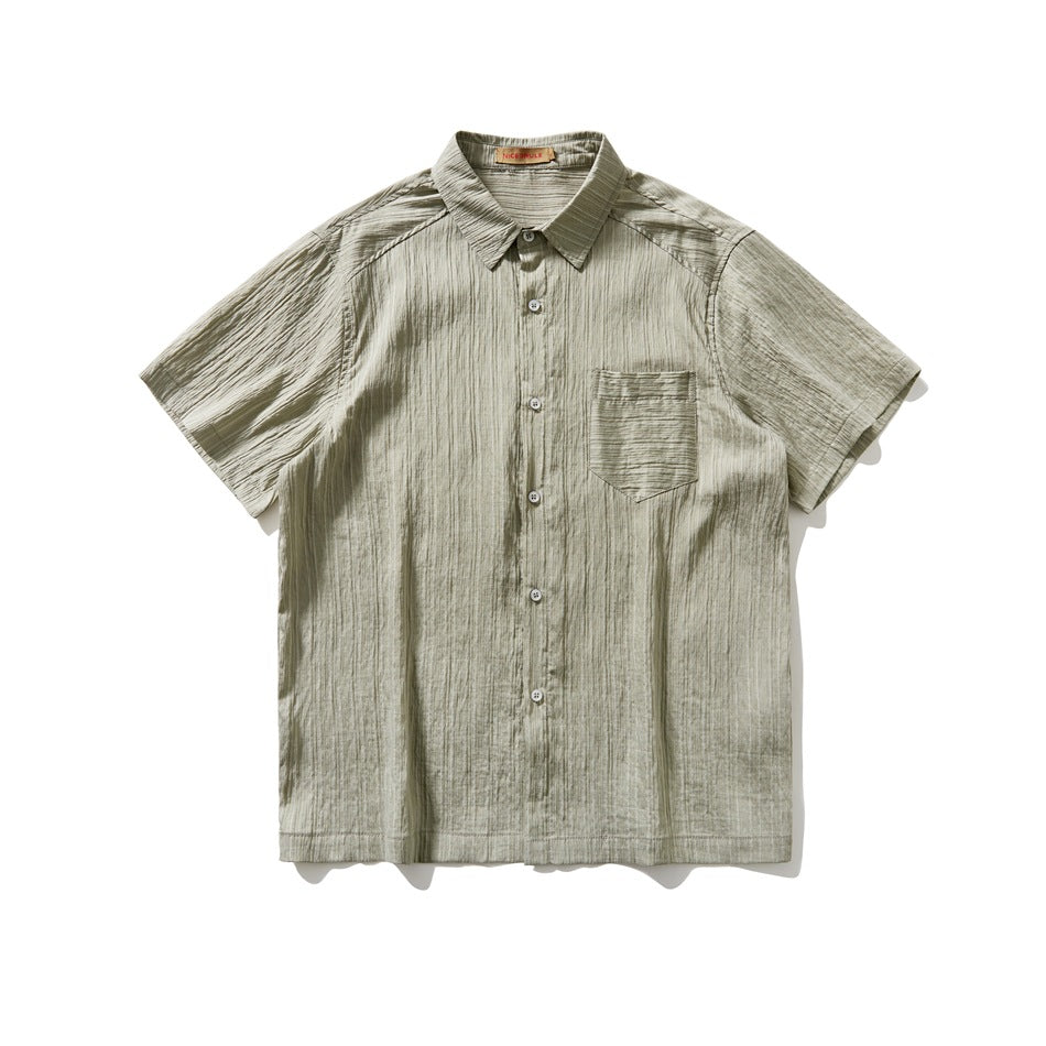 Sage green short-sleeve button-up shirt with chest pocket and crinkled striped texture, flat lay front view