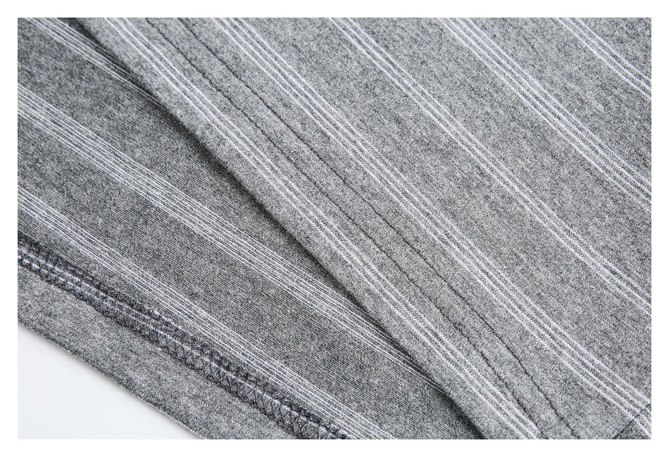 Close-up of the hem stitching and striped gray fabric of a shirt.