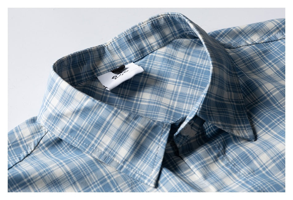 Close-up of a blue-and-white plaid short-sleeve shirt collar, placket, and sewn-in label.