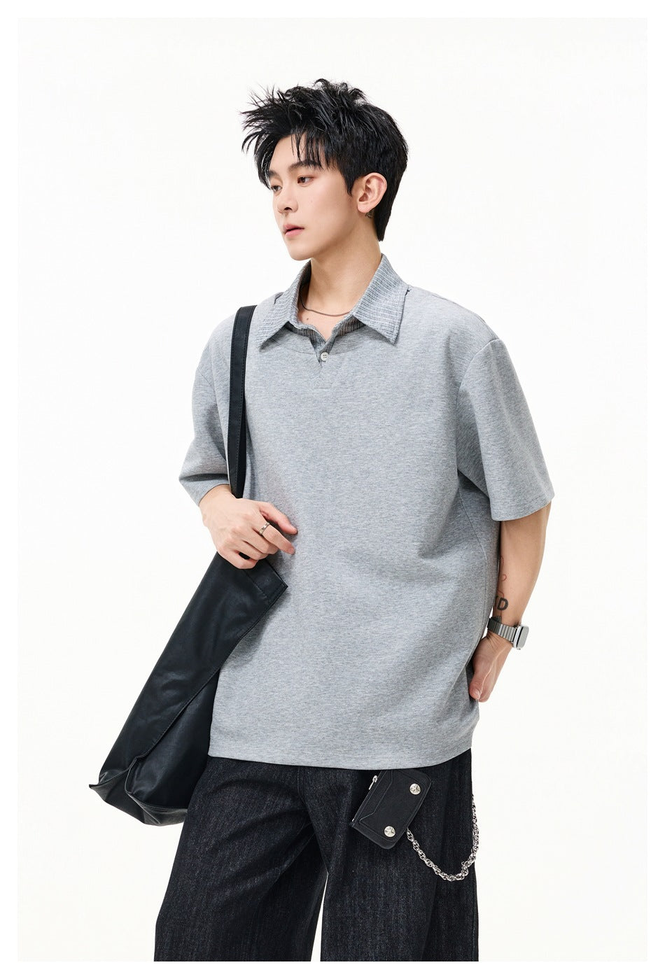 Closer view of a model wearing an oversized light gray short-sleeve polo shirt with a textured collar.