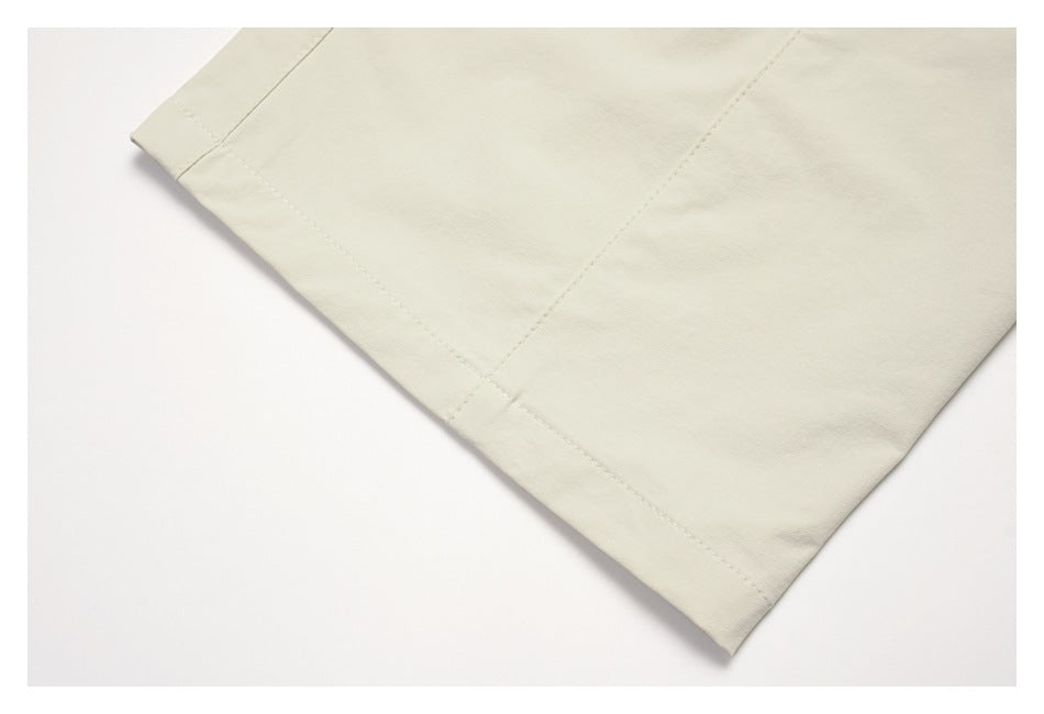 Close-up of a cream garment hem with visible stitching and a straight seam.