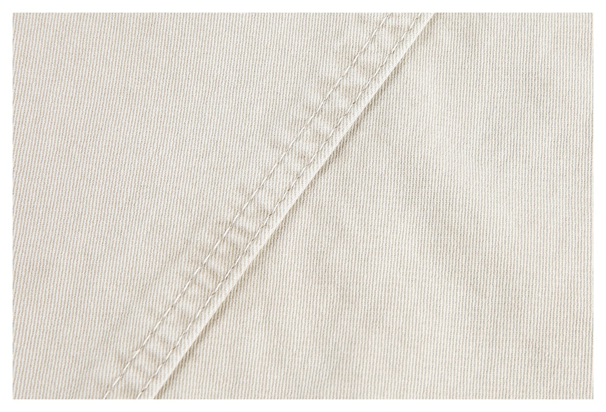 Close-up of a diagonal double-stitched seam on light beige pants.