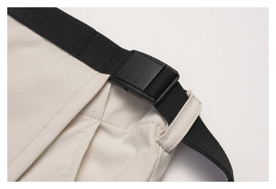 Close-up of the black waist strap and buckle where they attach to the beige skirt.