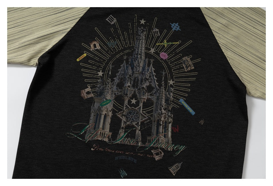Cropped front of a black top with beige sleeves and a large castle-and-star graphic.