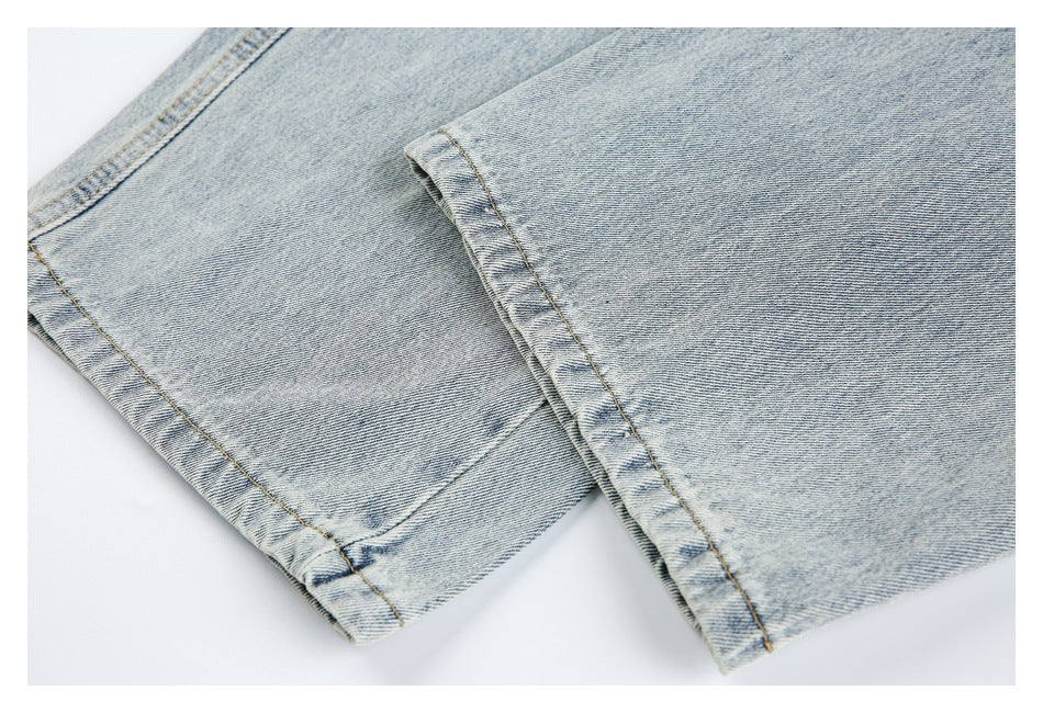 Close-up of overlapping light-wash jean legs showing the stitched hems and seams.