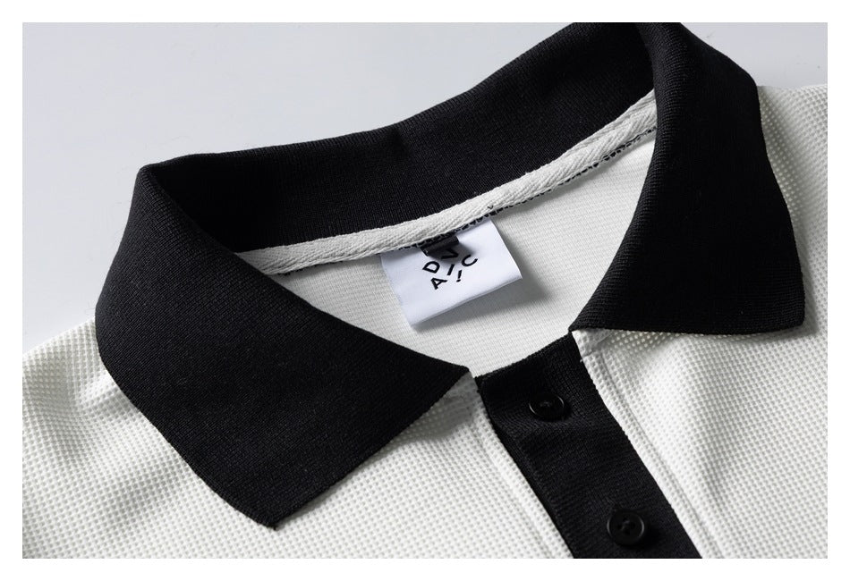 Close-up of a white textured polo shirt's black collar and two-button placket, with a sewn neck label visible.