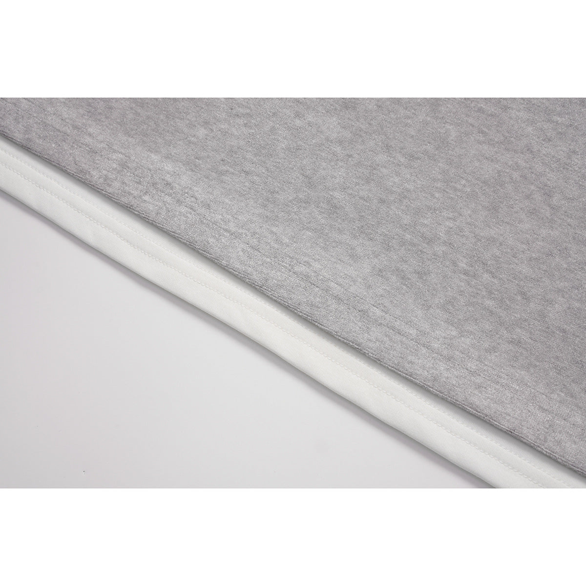 Close-up of the light gray top's lower edge, showing a white layer beneath the hem.