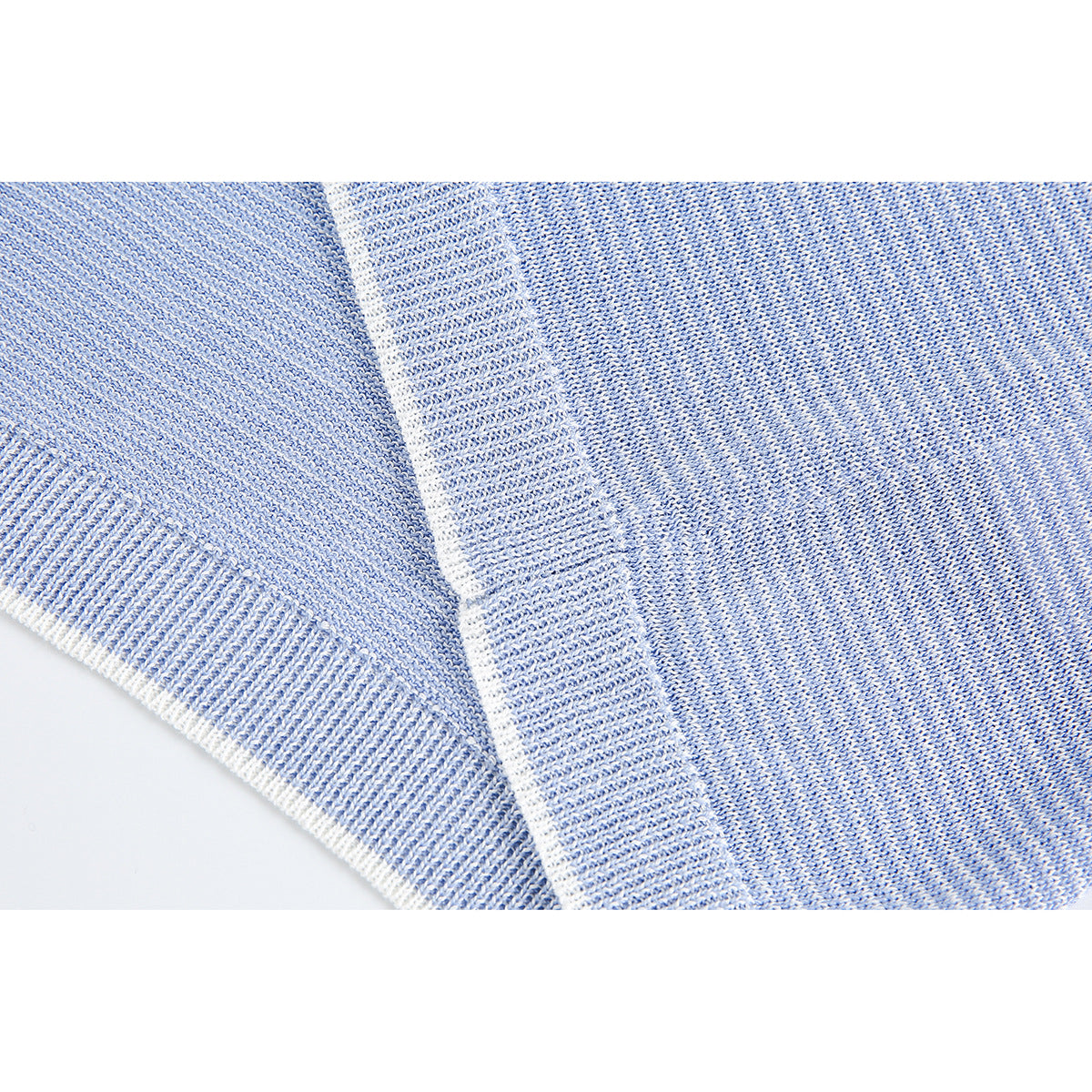 Close-up of blue-and-white knit fabric and a wide ribbed hem edge.