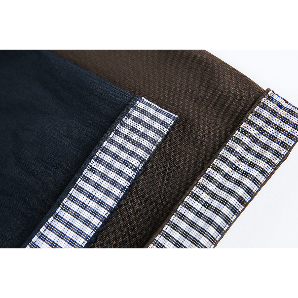 Close-up of checked cuff lining against navy and dark brown shirt sleeves.