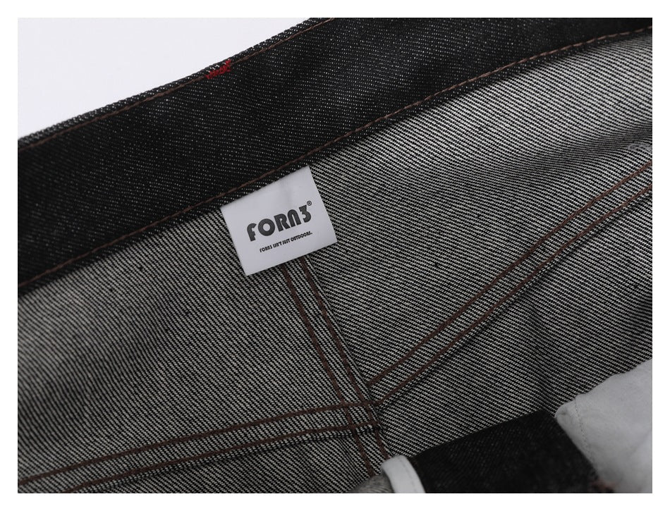 Close-up of black denim with brown contrast stitching and a sewn-in FORO label.