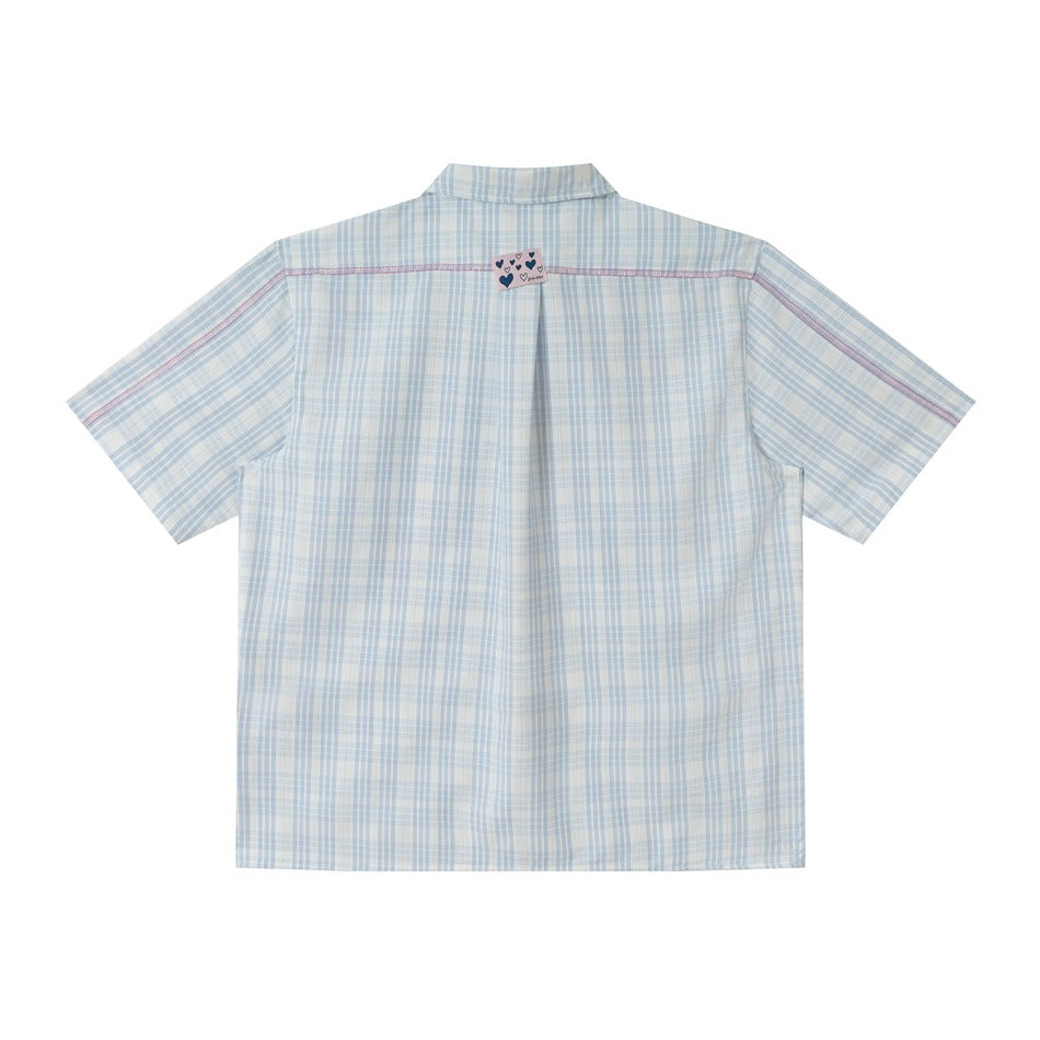 Back of blue plaid short-sleeve shirt with pink contrast topstitching and heart label at neck