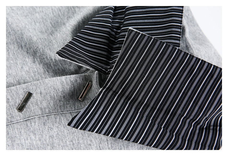 Close-up of the gray shirt's black lining with thin white stripes beside its collar and metal accents.
