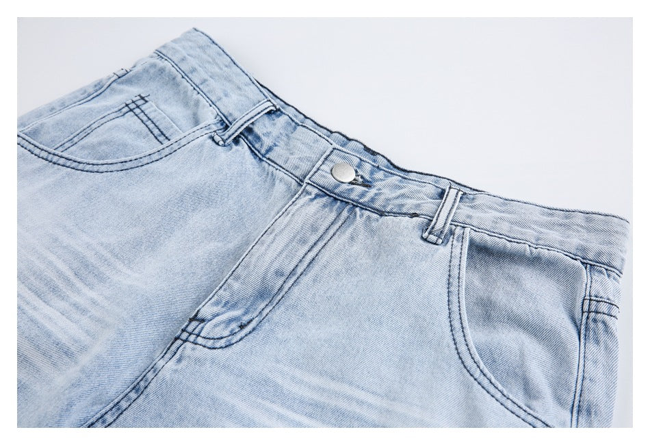 Close-up of the light-wash denim shorts’ waistband, button, belt loops, and front pocket stitching.