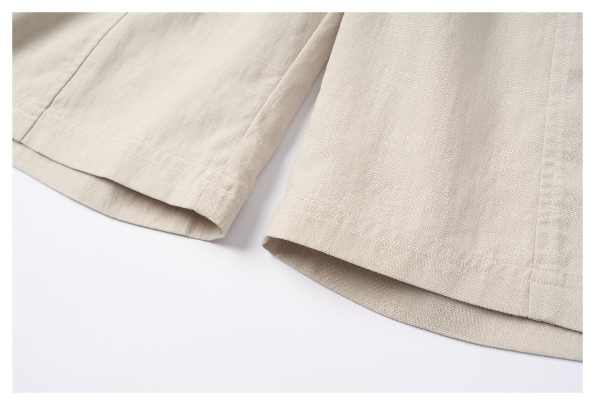 Close-up of the cream garment's lower hems, showing stitched seams and a loose, relaxed cut.