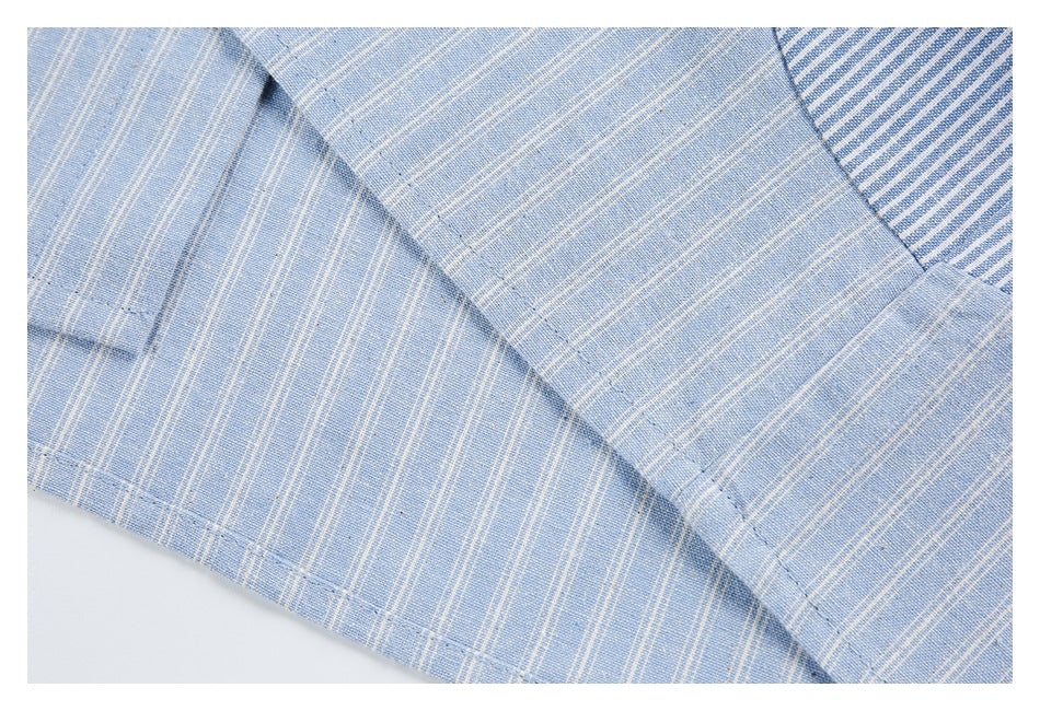 Close-up of stitched seams and overlapping light blue striped fabric, with a contrasting blue-and-white stripe panel.