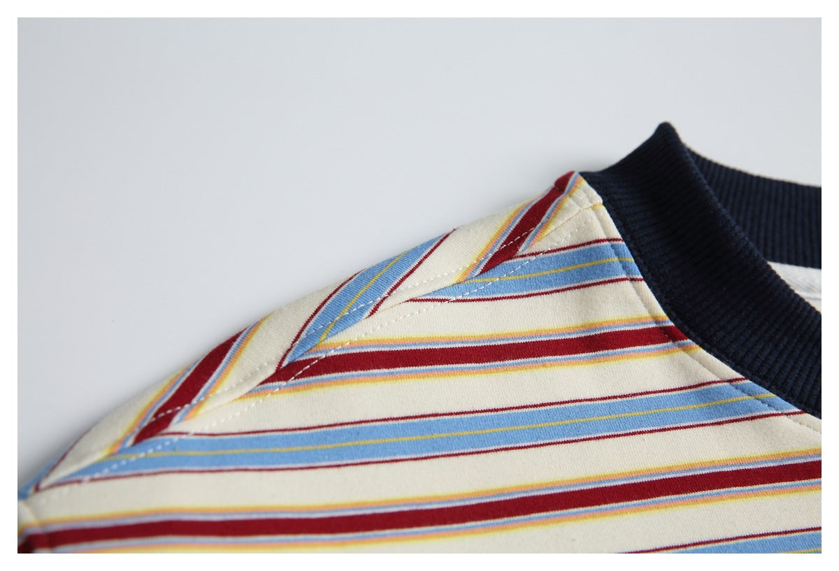 Close-up of the striped T-shirt's shoulder seam and stitching beside the dark ribbed collar.