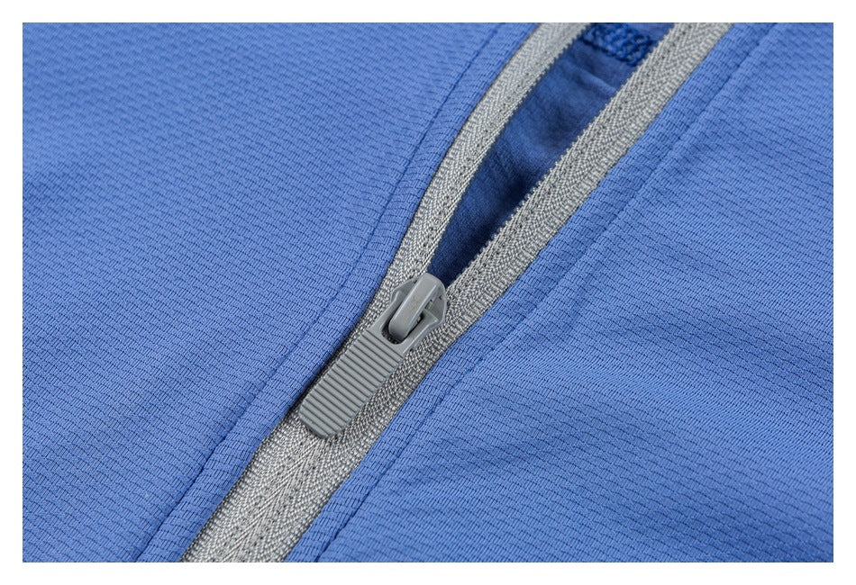 Close-up of a gray zipper set into blue garment fabric.