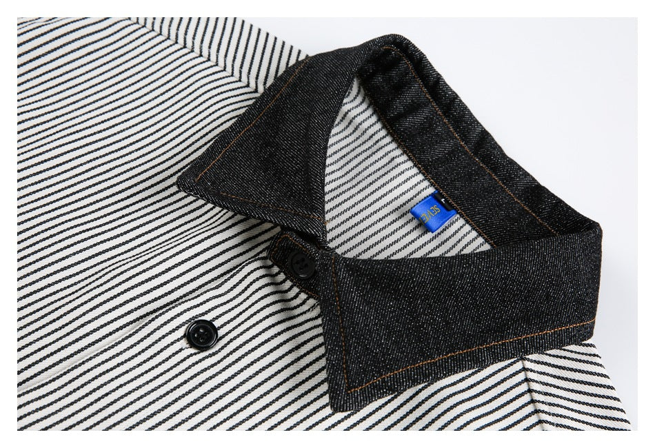 Close-up of a striped shirt collar with dark denim-like contrast fabric, black buttons, and a small blue tag.