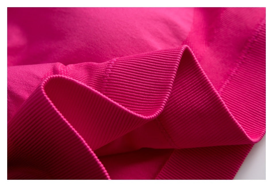 Macro view of the pink top's folded ribbed band and stitching.