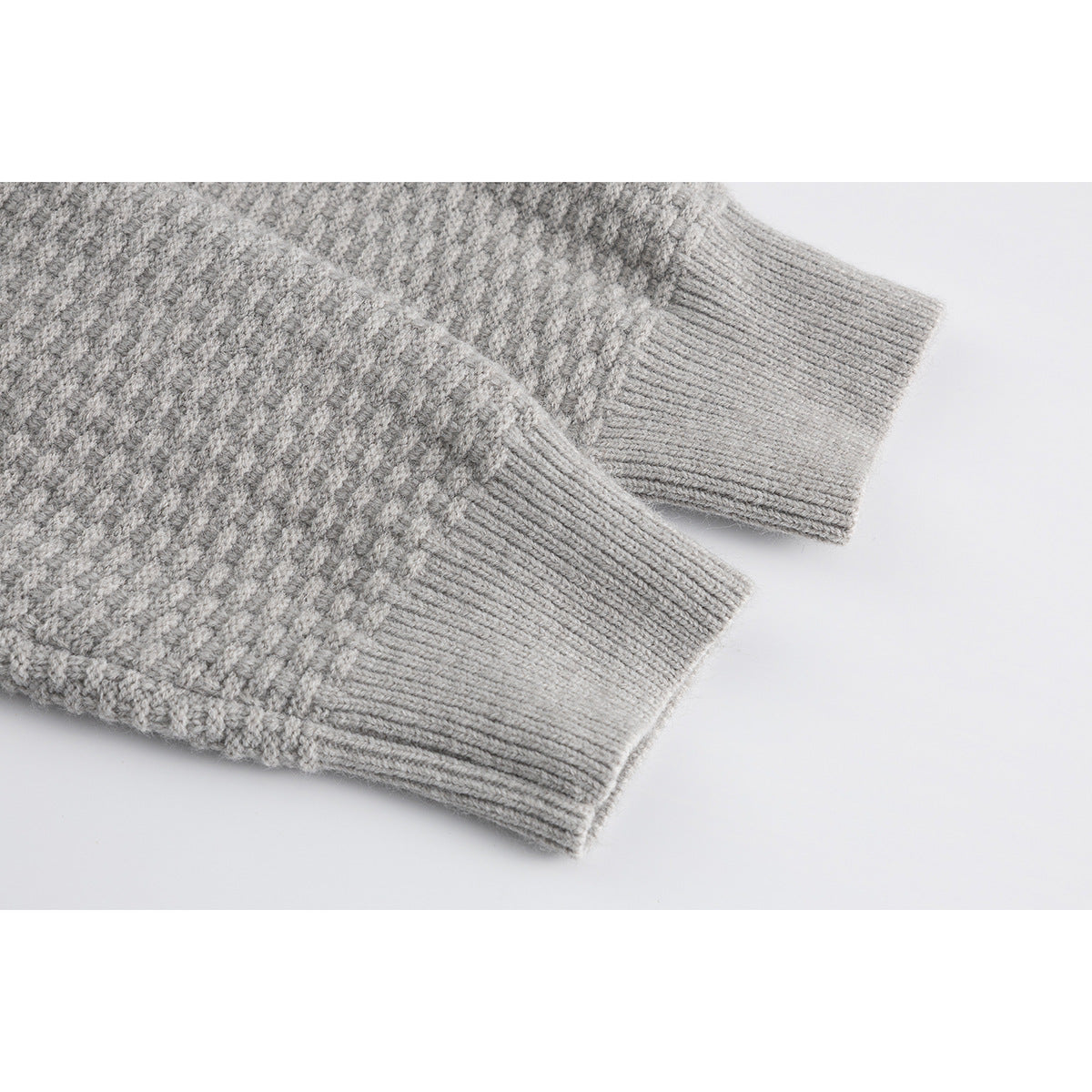 Close-up of the light gray cardigan's textured knit and ribbed sleeve cuffs.
