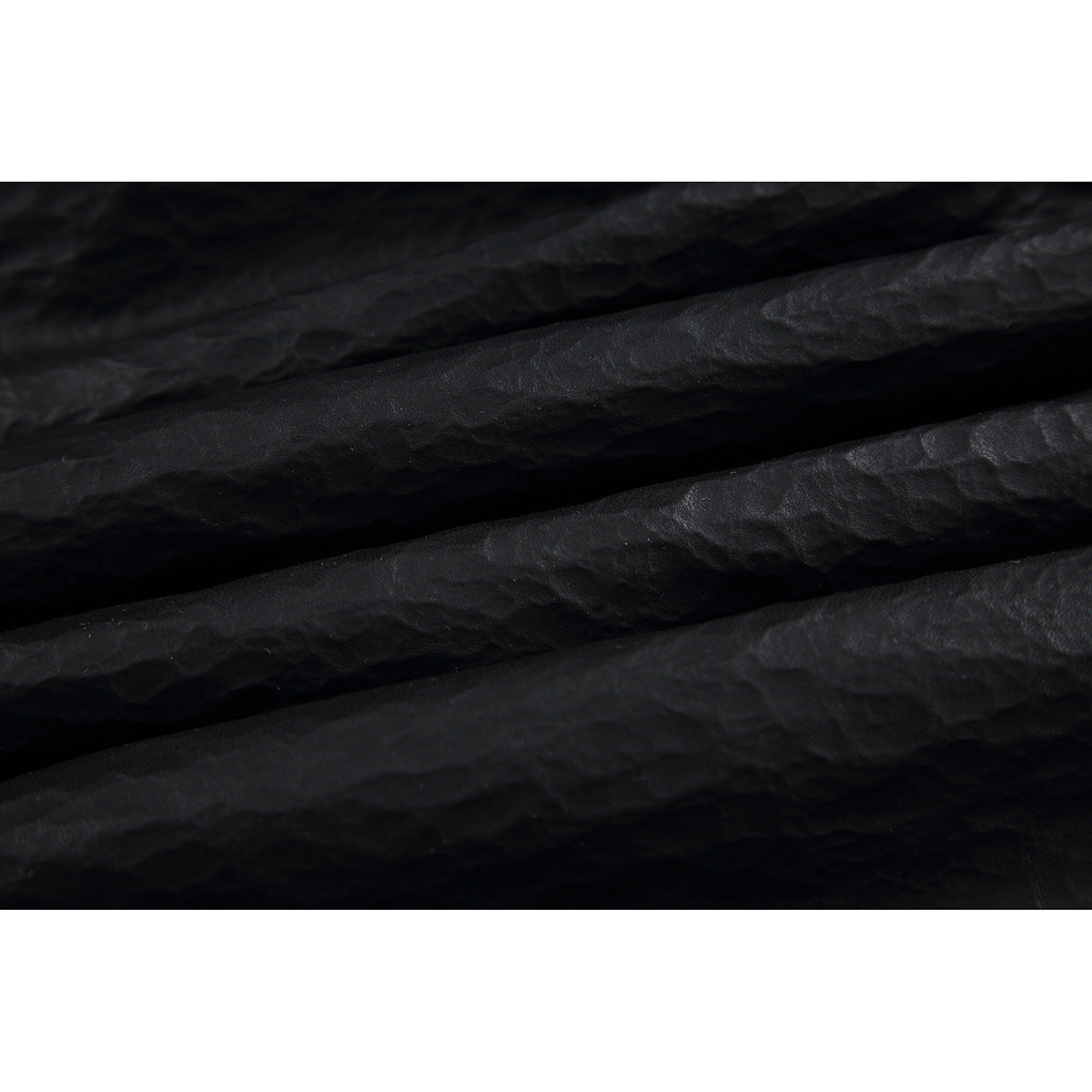Extreme close-up showing the black garment's crinkled surface and folds.