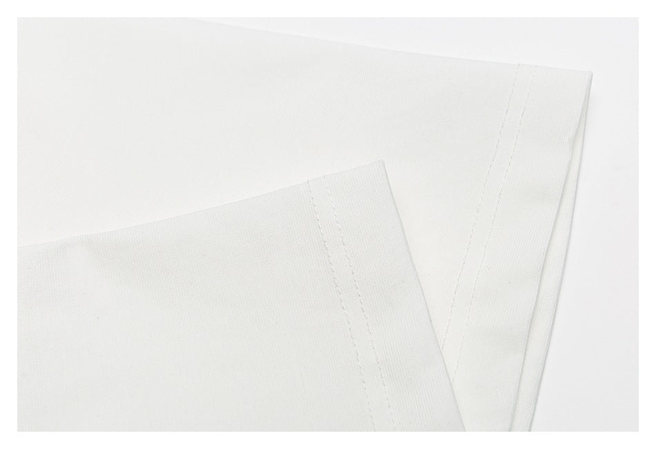 Close-up of the white T-shirt's folded hem edges and parallel stitching.