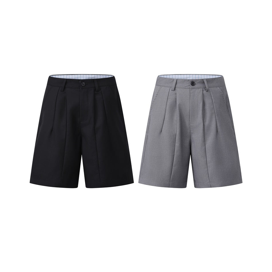 Two pairs of pleated shorts shown from the front, one black and one gray.