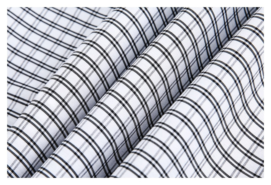 Close-up of white fabric draped in folds, showing a black and gray plaid pattern.