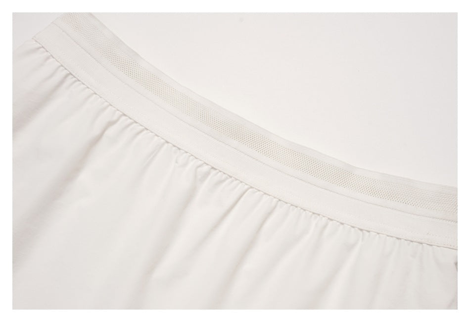 Close-up of the white skirt's gathered waist and textured elastic waistband.