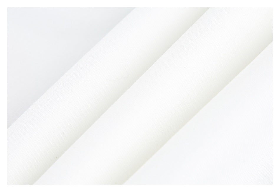 Close-up of white fabric folded into diagonal ridges, showing a fine textured surface.