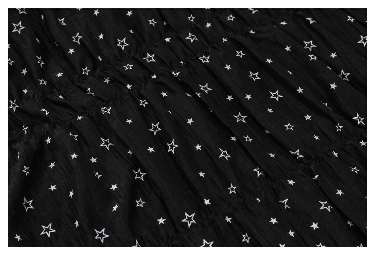 Close-up of gathered seam detailing on black fabric with a scattered white star print.