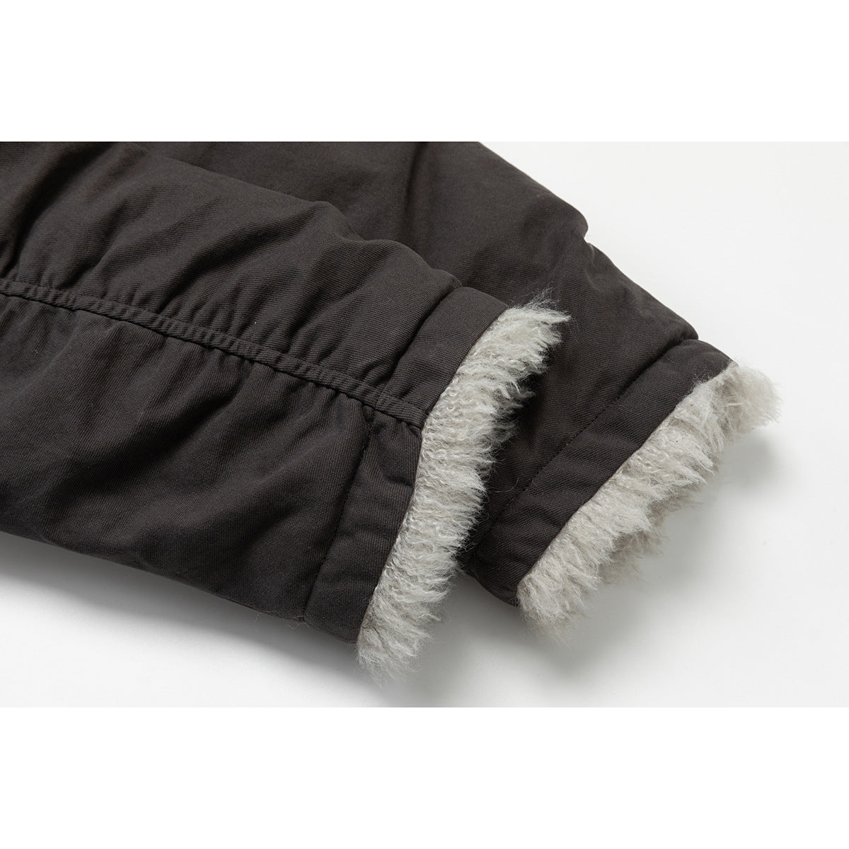Close-up of the parka sleeve cuffs, showing gray fur lining beneath the dark outer fabric.