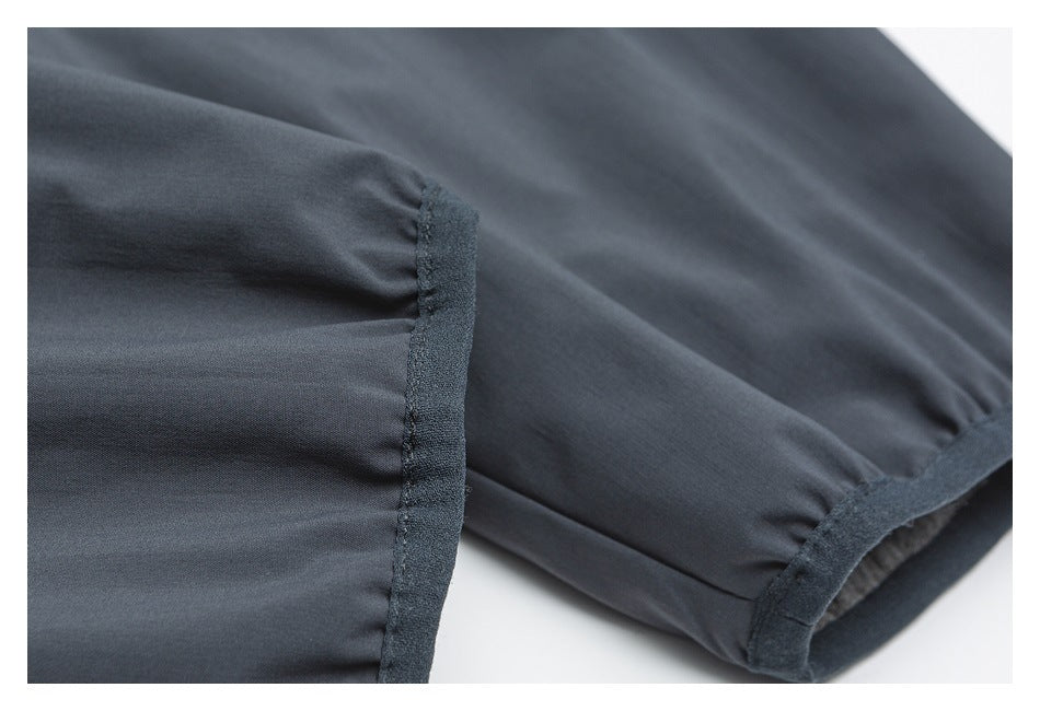 Close-up of a dark charcoal sleeve cuff with a dark bound edge and visible stitching.