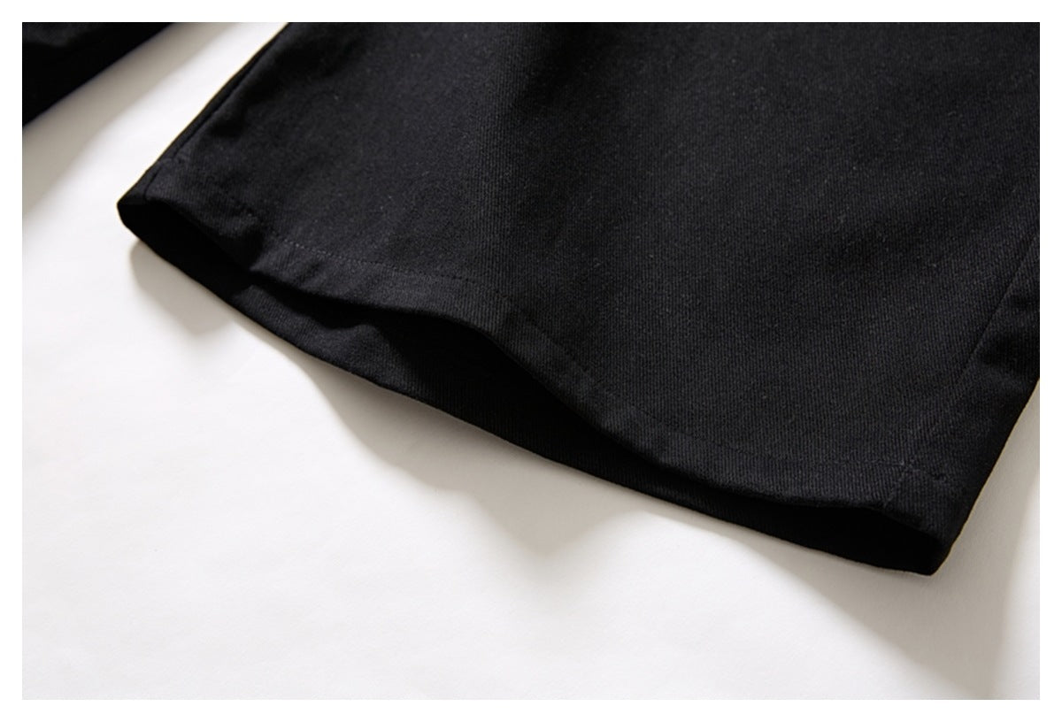 Close-up of the straight stitched hem on black trousers.