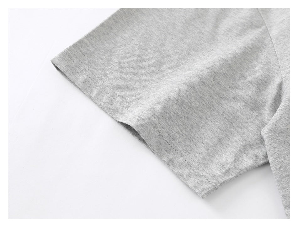 Close-up of a light gray heather T-shirt sleeve and stitched edge on a white background.